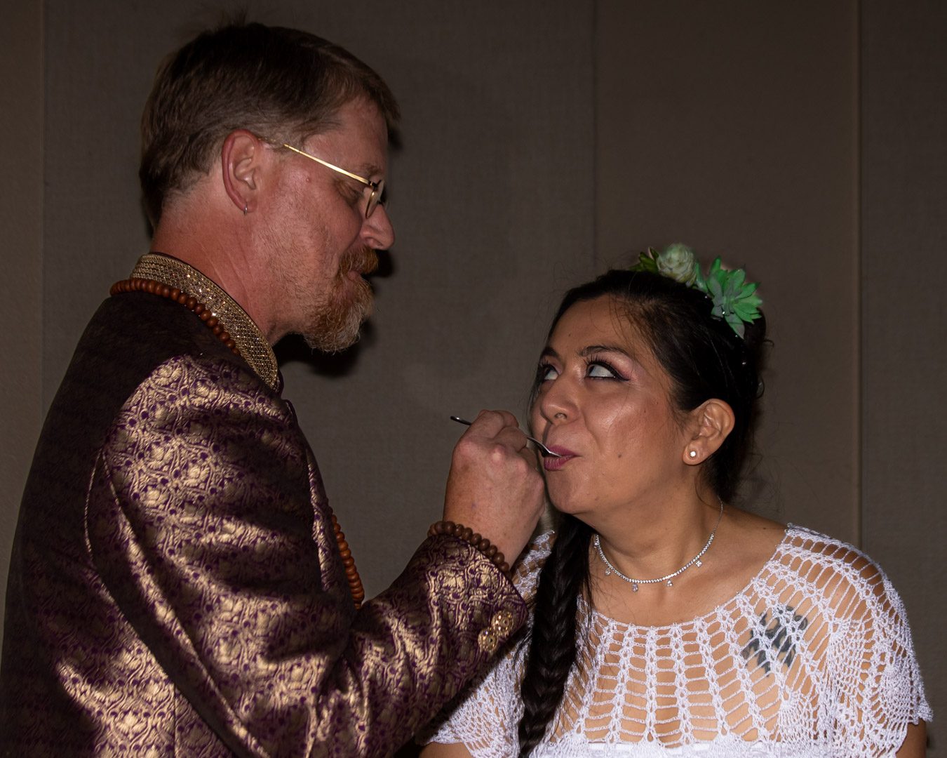 Groom feeding the bride a spoonful of cake