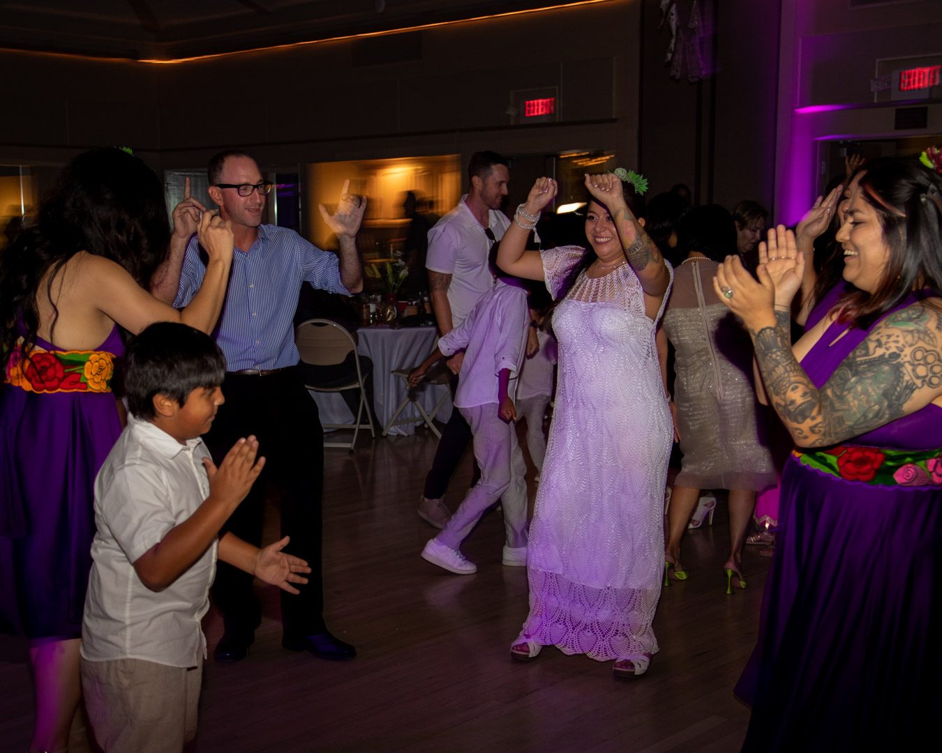 Bride and guests dancing and clapping on a crowded dance floor